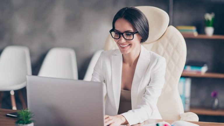 business woman smiling at laptop selling life insurance